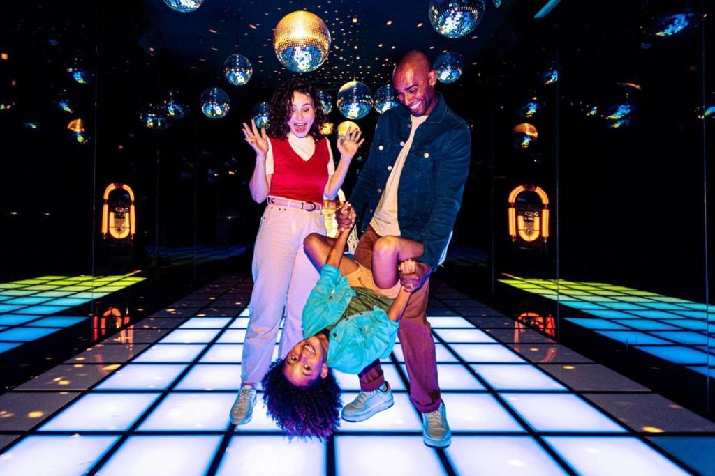 Una familia baila de alegría en la sala Chromadance de Dopamine Land