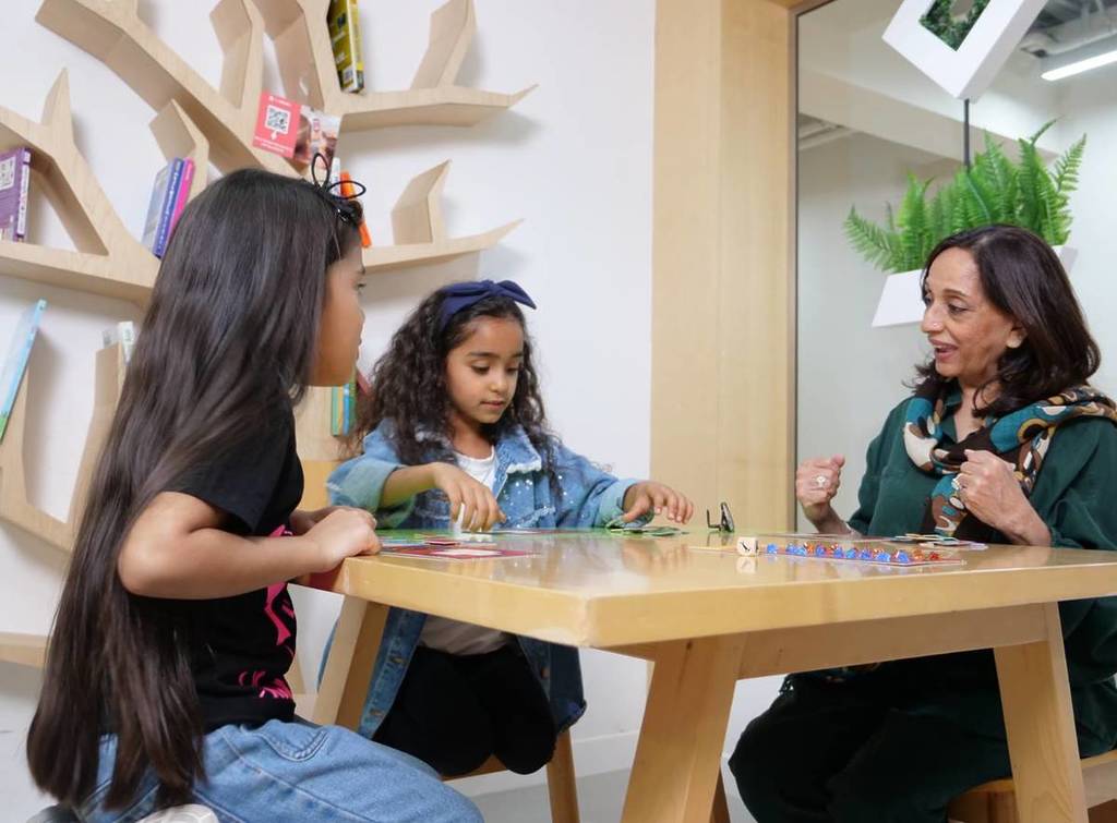 Zwei Kinder bei der Interaktion mit einer der woo-hoo! Dubais Aktivitäten im The Nest, dem Café vor Ort.