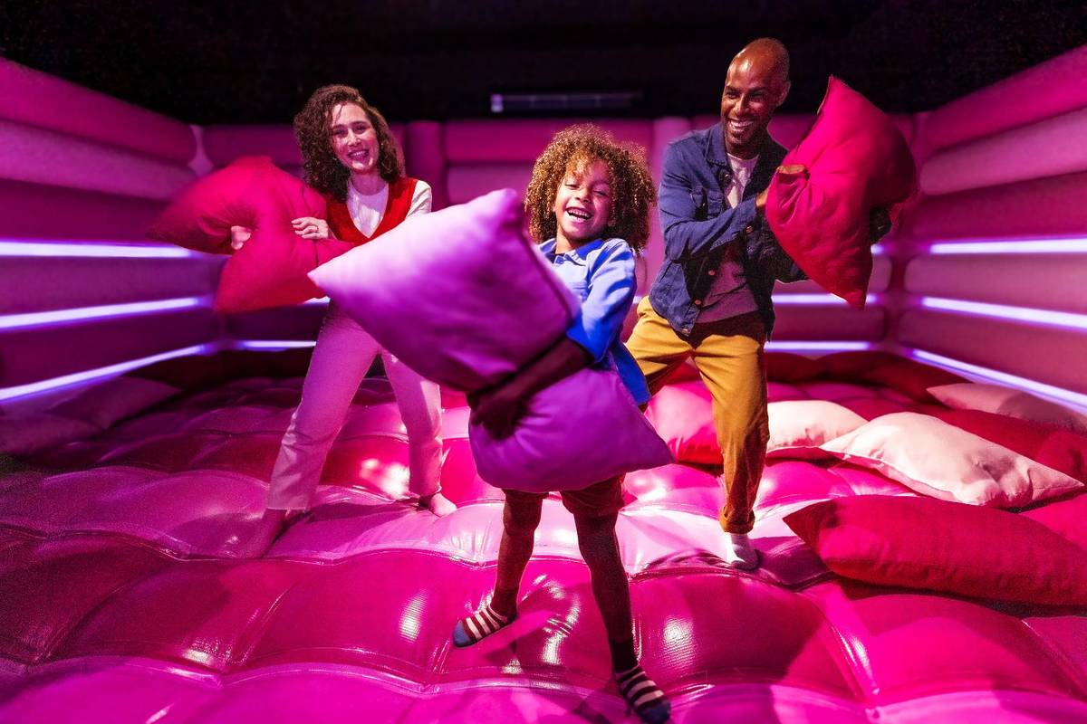A family having a pillow fight in Dopamine Land's cushion clash room