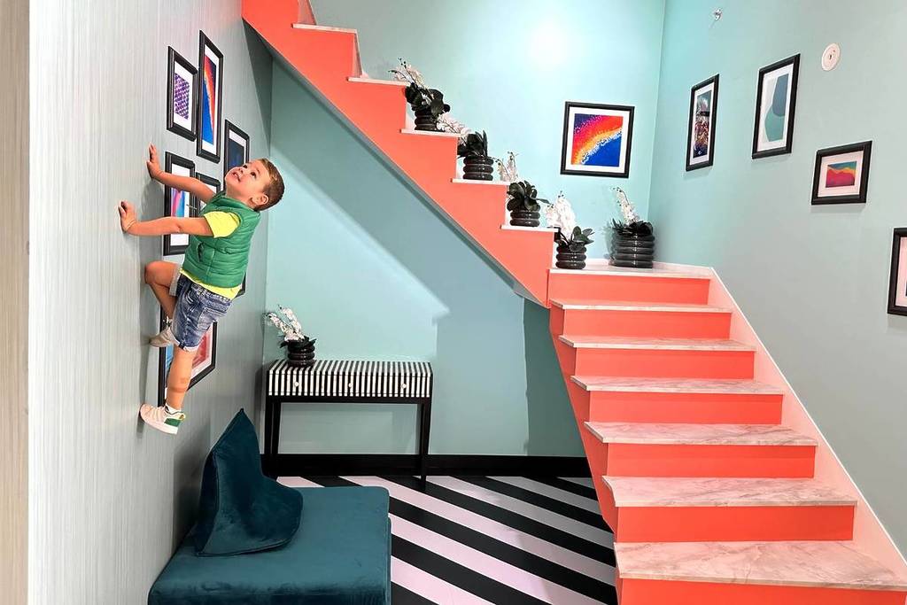 Una delle stravaganti mostre di Illusion City Dubai, dove un bambino sembra strisciare sui muri