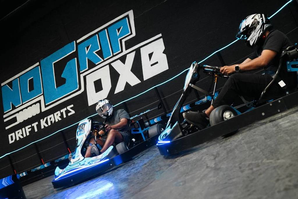 Dos de los karts de drifting de No Grip DXB aparcados frente al letrero del recinto