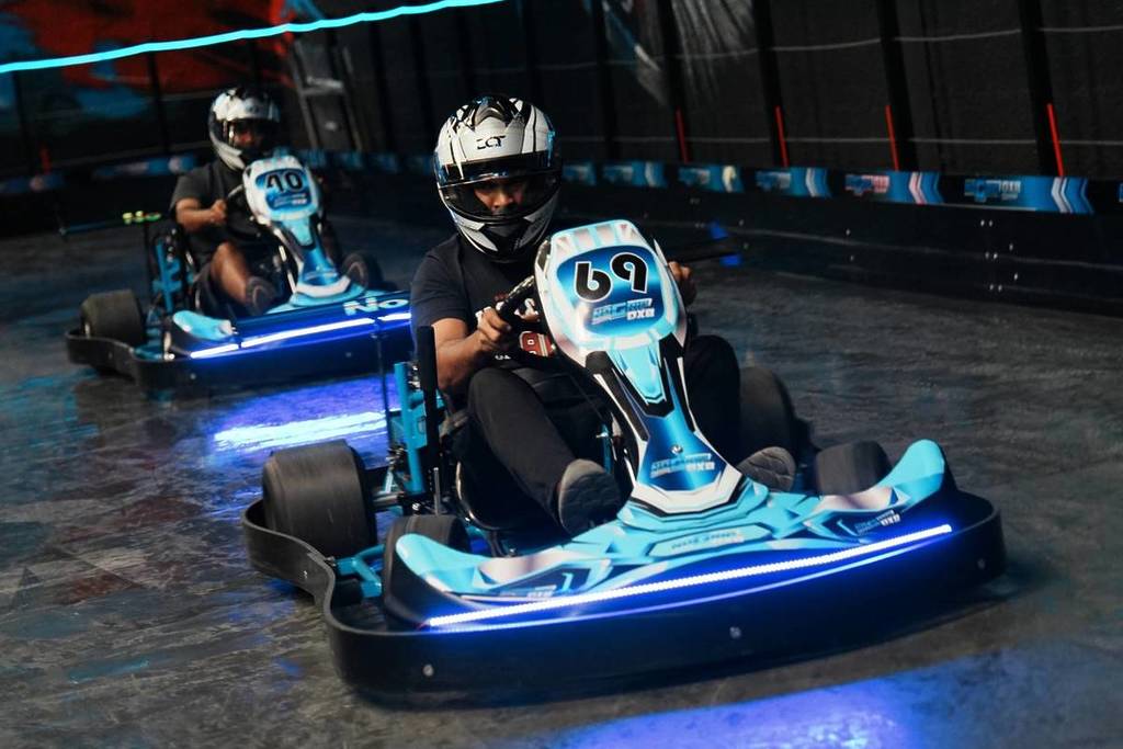 Dos pilotos haciendo derrapes con sus karts por la pista especializada