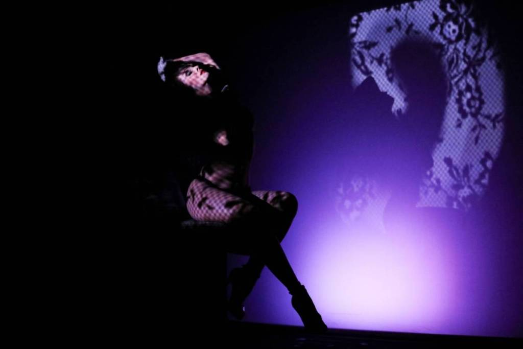 Una donna che balla, usando luci e ombre per creare illusioni ottiche