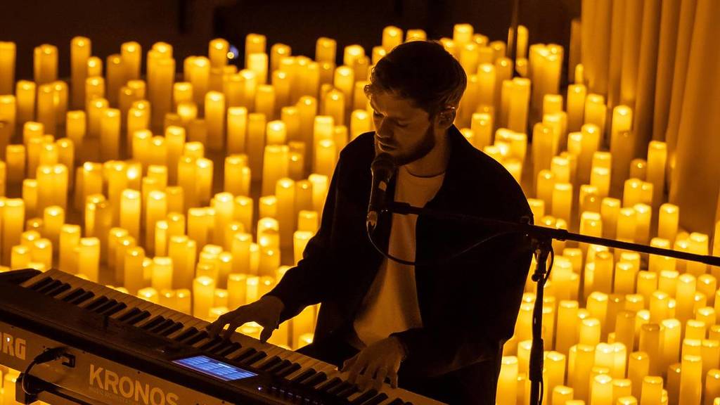 James TW performs at a candlelight concert