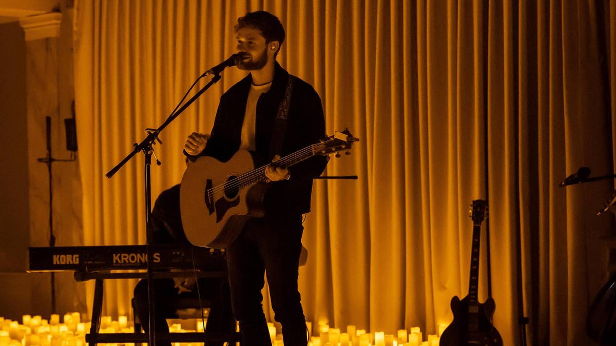 James TW plays guitar at a candlelight concert