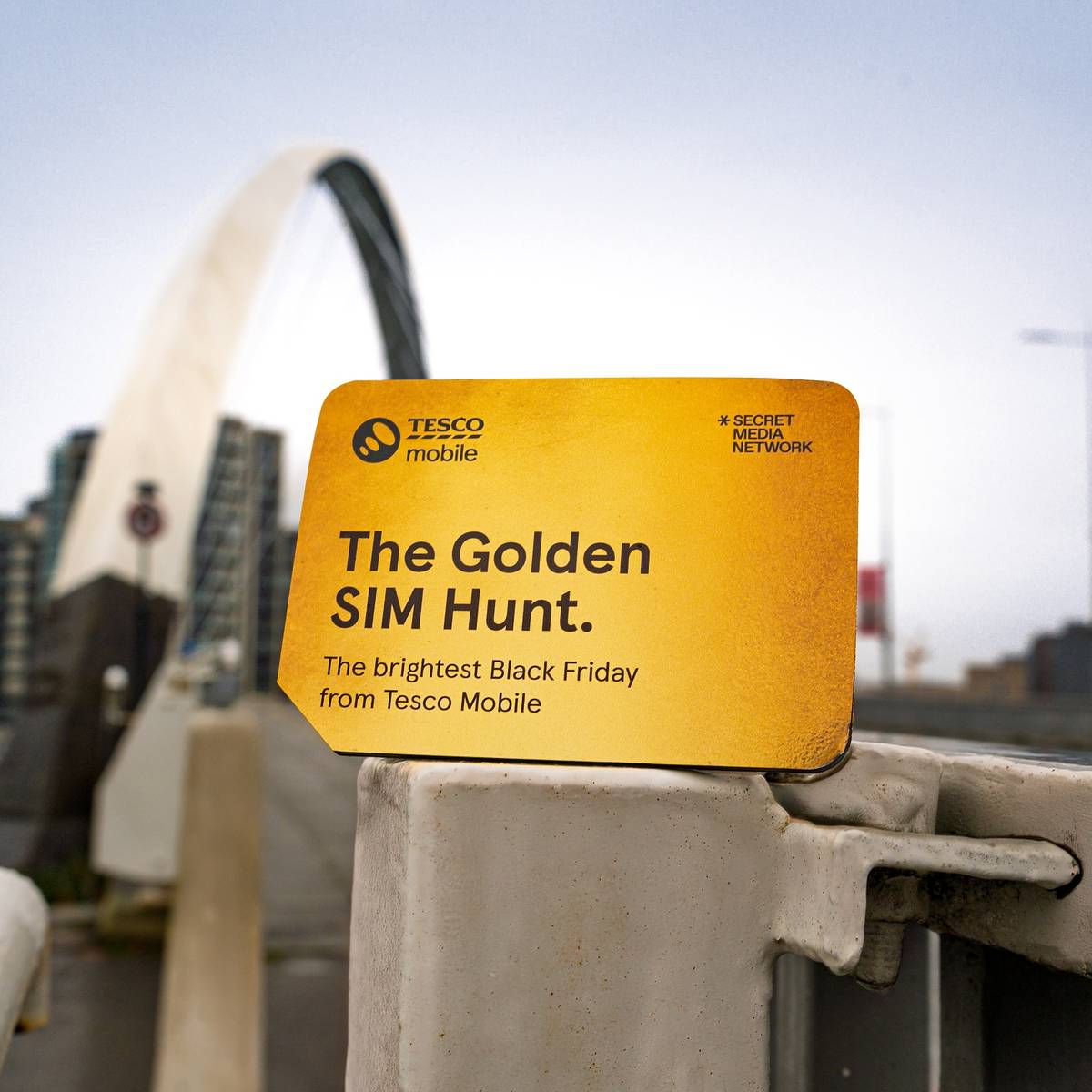a tesco mobile golden sim card hidden by a glasgow bridge