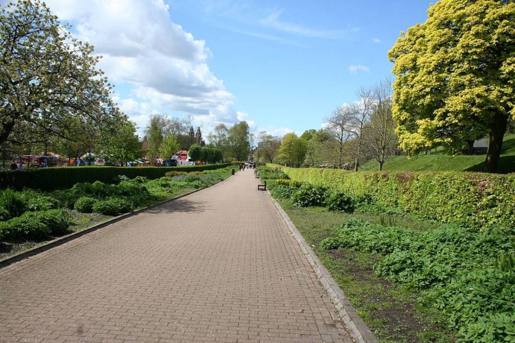An empty path in Kelvingrove Park, blue skies, and bright grass