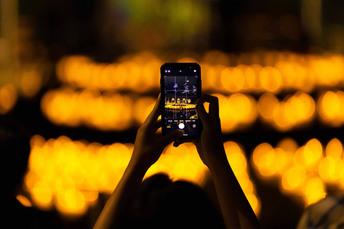 An audience member records a Candlelight concert with their phone.