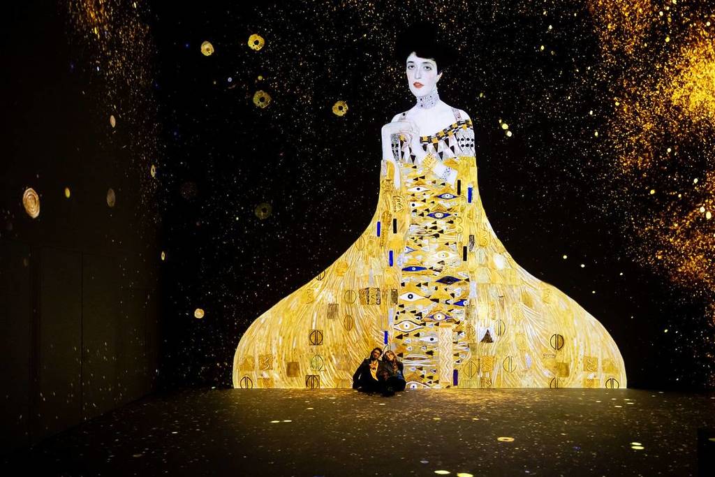 Sitzen unter einer riesigen Projektion von Klimts Porträt von Adele Bloch-Bauer I in Hamburg