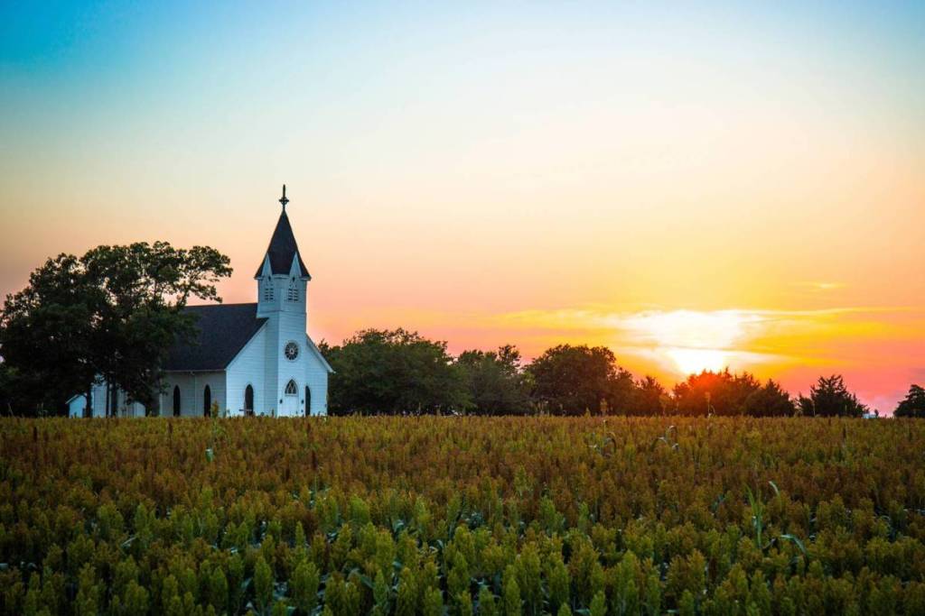 Kirche in einem Feld bei Sonnenuntergang