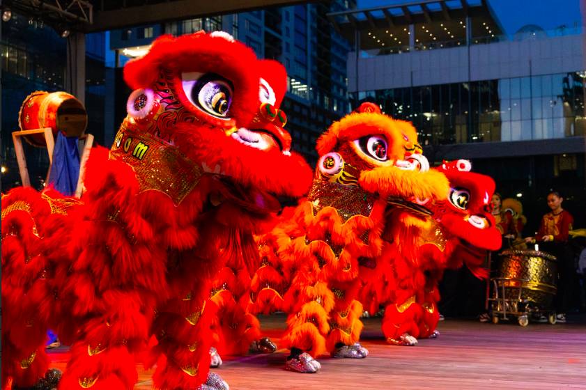 Image shows a dragon dance performance at Discovery Green in Houston. 