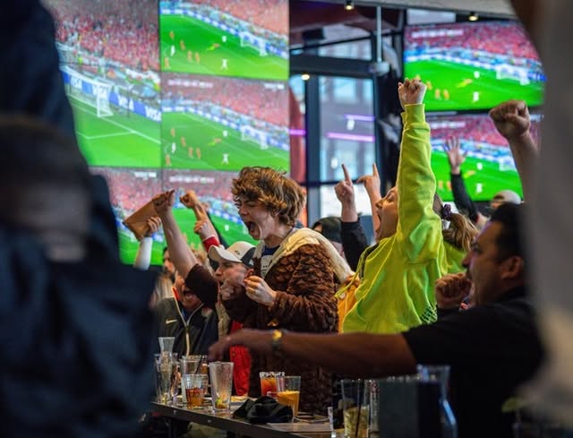 La imagen muestra a gente animando dentro del Tom's Watch Bar. 