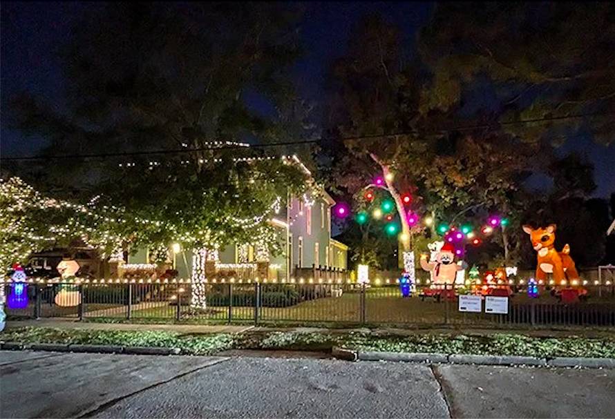 Image shows a home decorated in Christmas lights with inflatable and other installations in Woodland Heights in Houston.