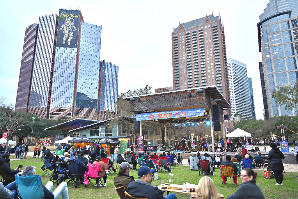 Image shows a group of people in Houston enjoying Jazzy Sundays in the Park with the Houston skyline in the background.