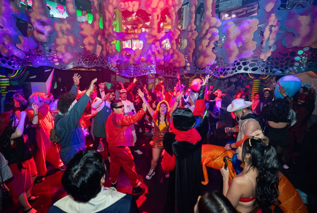 Image shows a costume party of dancing people at Meow Wolf Houston.
