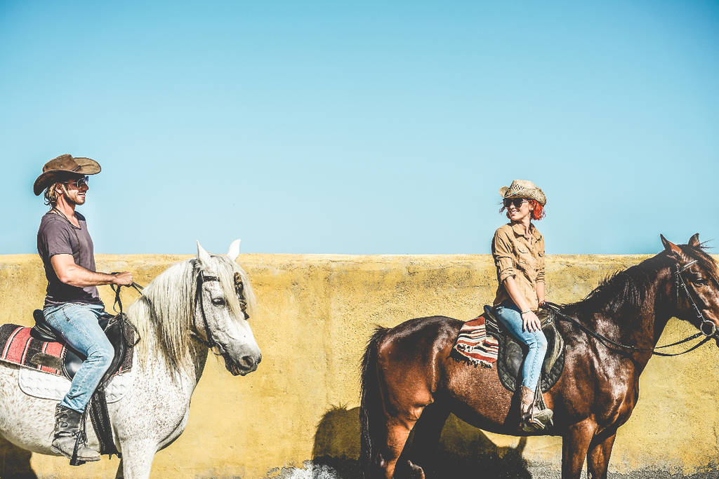 Image shows a couple on horseback in Texas.