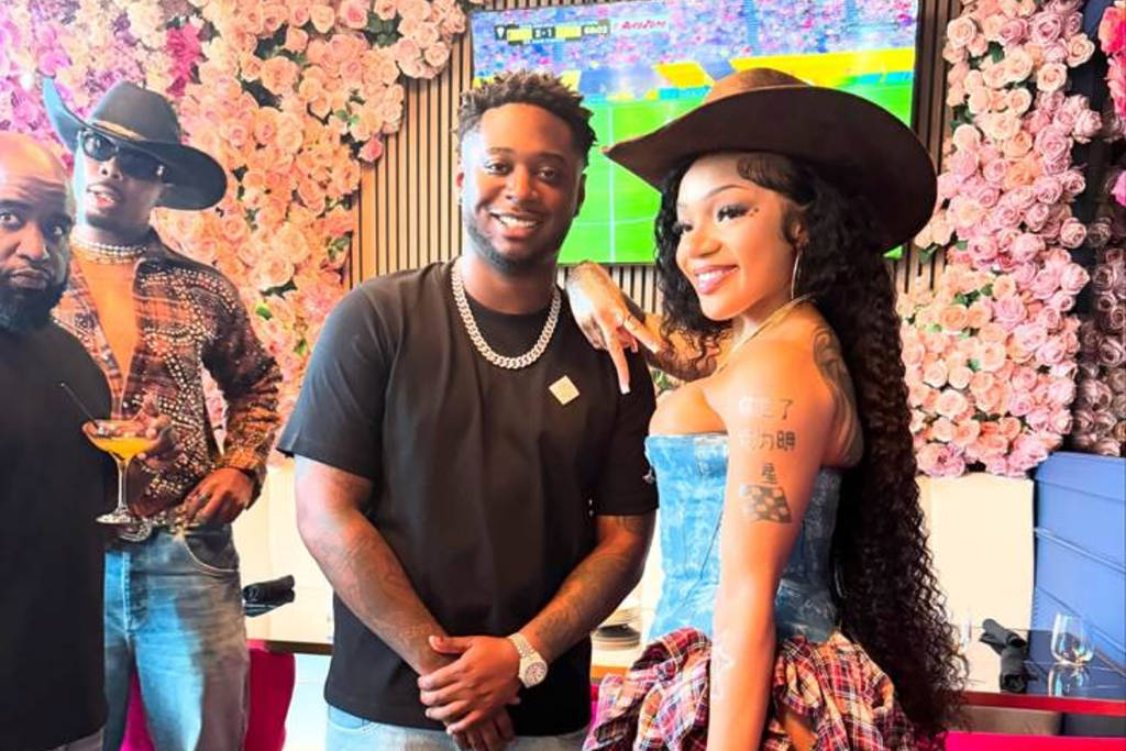Image shows Confessons Restaurant & Lounge founder, Sterling Lewis, posing with GloRilla