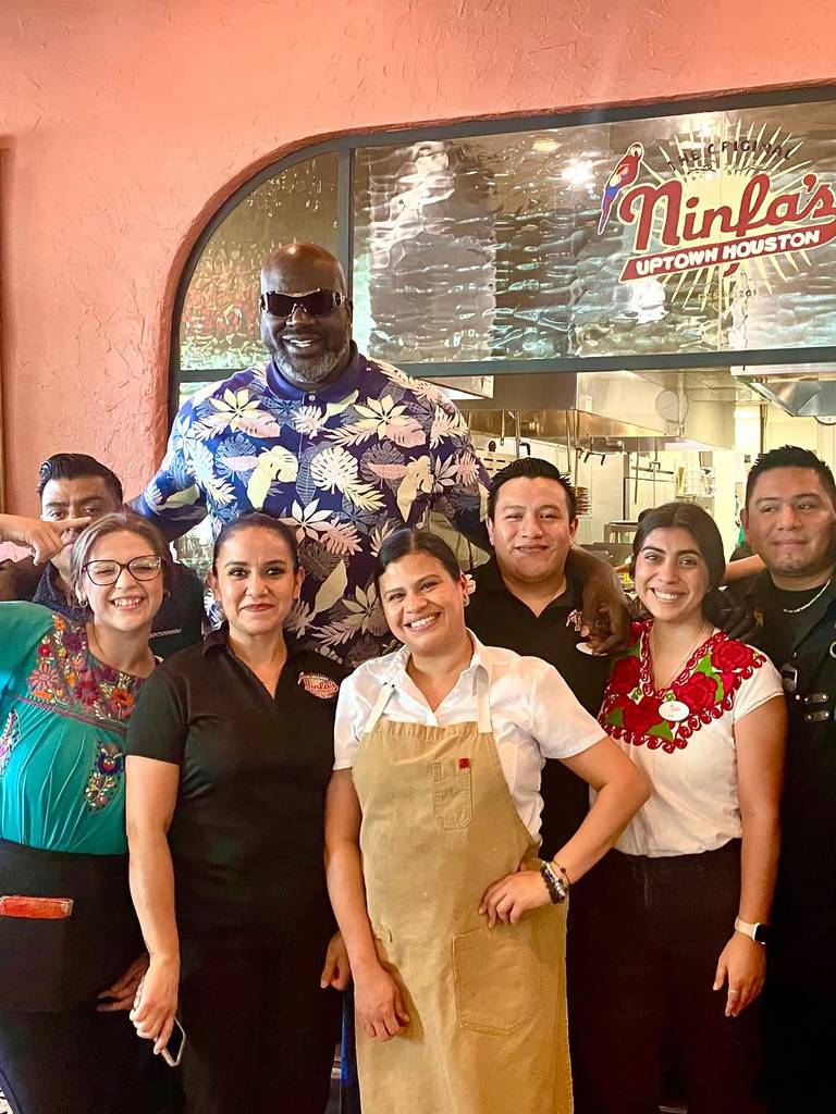 Image shows Shaquille O'Neal posing with the staff at The Original Ninfa's Uptown in Houston.