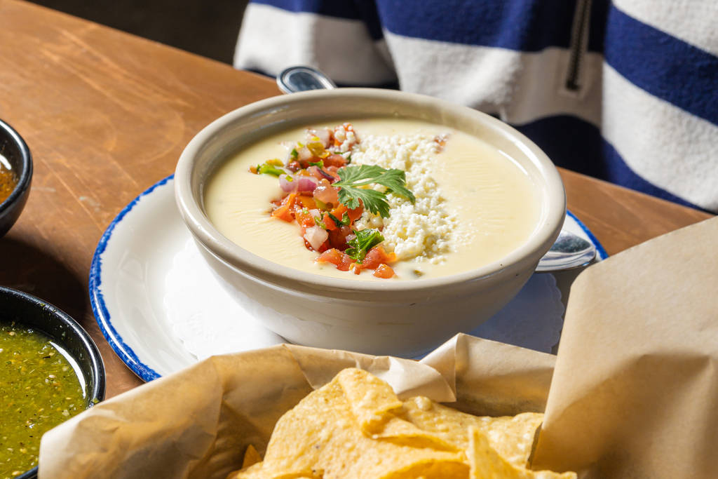 Image shows a bowl of queso with chips on the side at Candente in Houston.