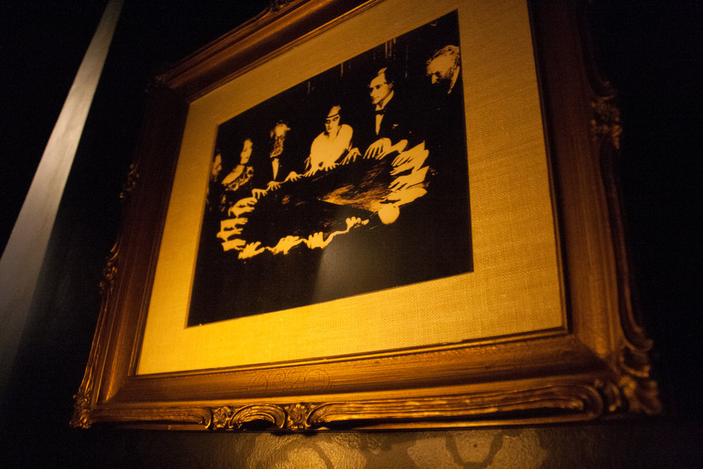 Image shows a photograph of a seance on the set of The Man From Beyond at Strange Bird Immersive in Houston