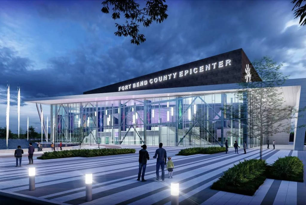 Image shows the Fort Bend Epicenter at night with two people standing in front.