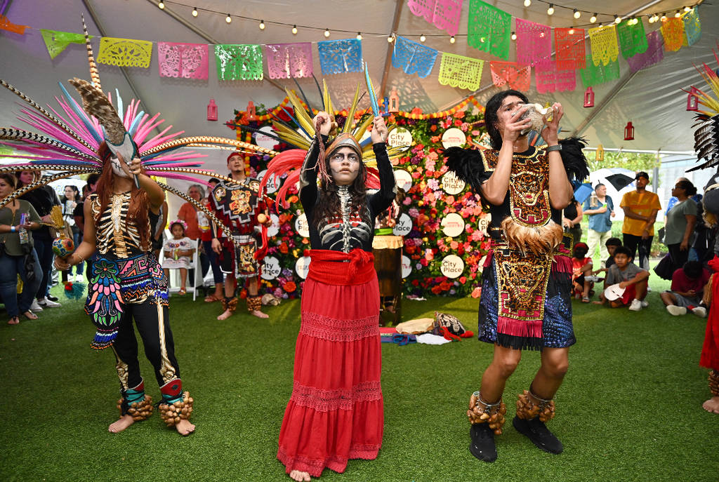 Image shows the Dia de los Muertos celebration at City Place in Houston featuring attendants with traditional costumes.