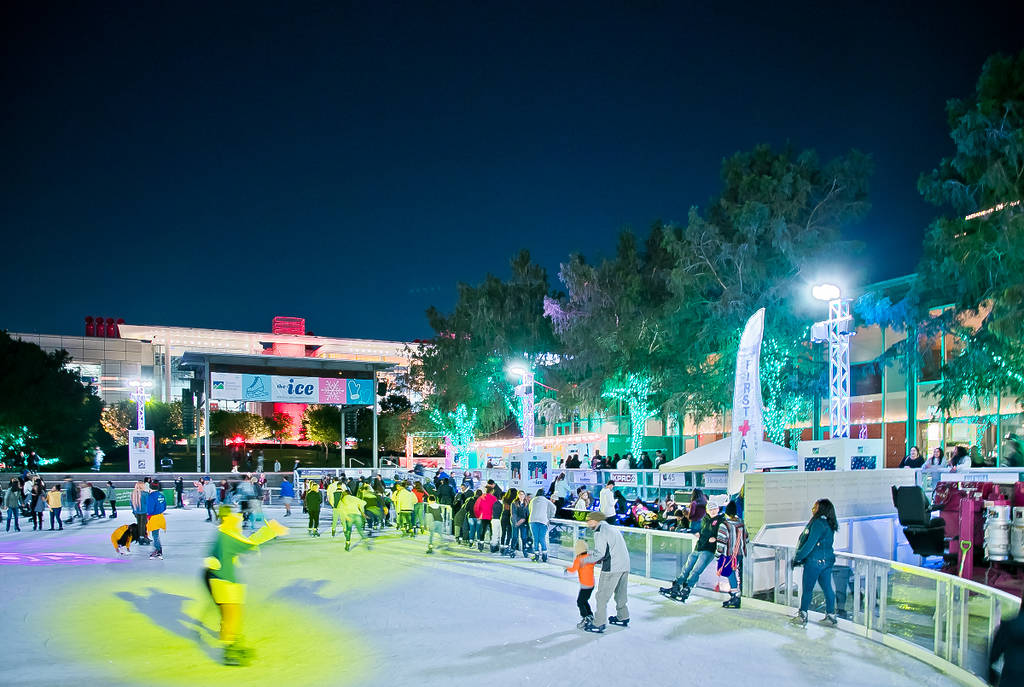 Image shows people skating at the Ice at Discovery Green downtown Houston ice rink.