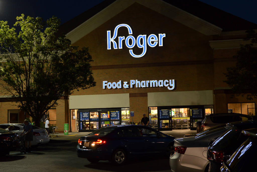La imagen muestra una fachada de Kroger por la noche.