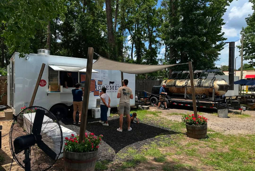 Image shows people lining up at the trailer and kitchen of Rosemeyer Bar-B-Q in Houston.