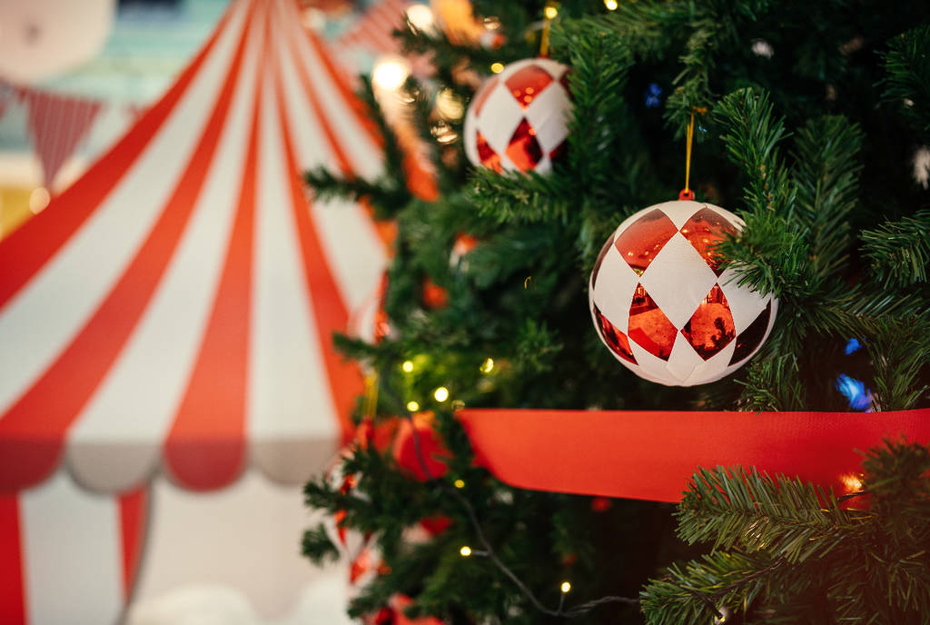 Image shows a decorated Christmas tree with a tent in the background.