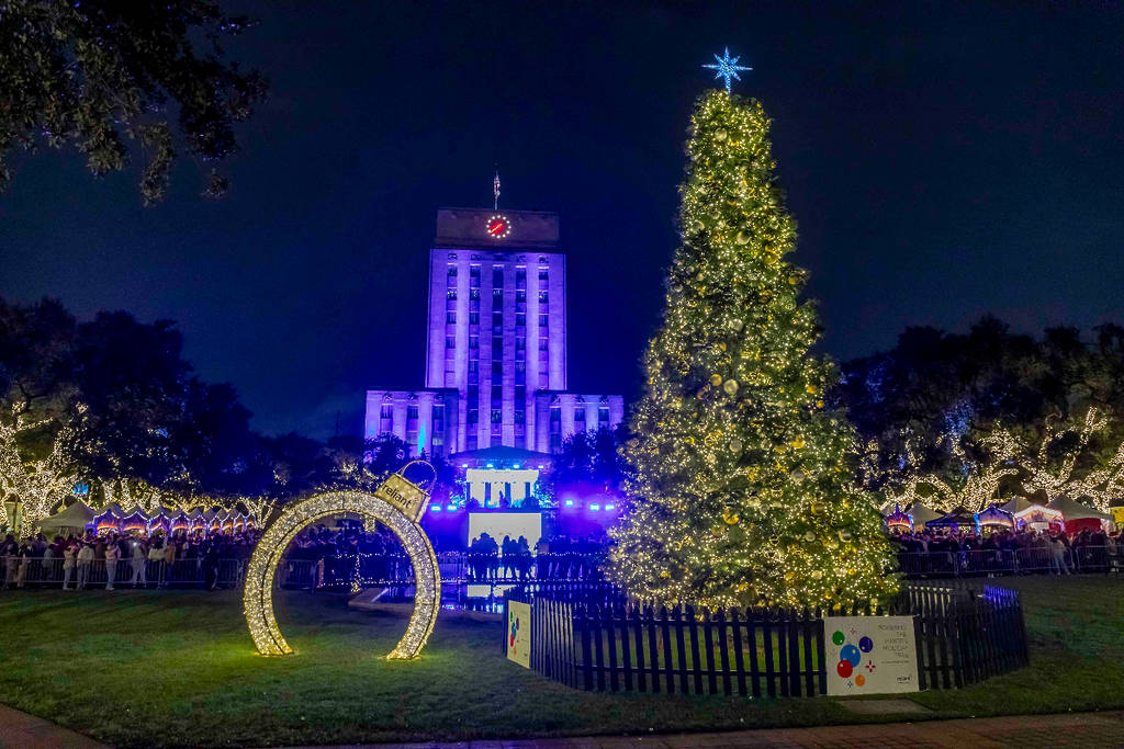 Image shows a Christmas tree in lights next to two holiday installations in Houston.