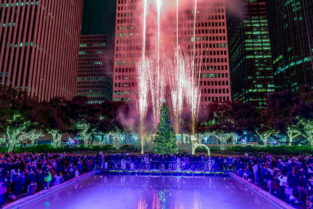 La imagen muestra fuegos artificiales alrededor de un árbol de Navidad en Hermann Square en Houston para Deck the Hall: Concierto de luces del árbol navideño del alcalde