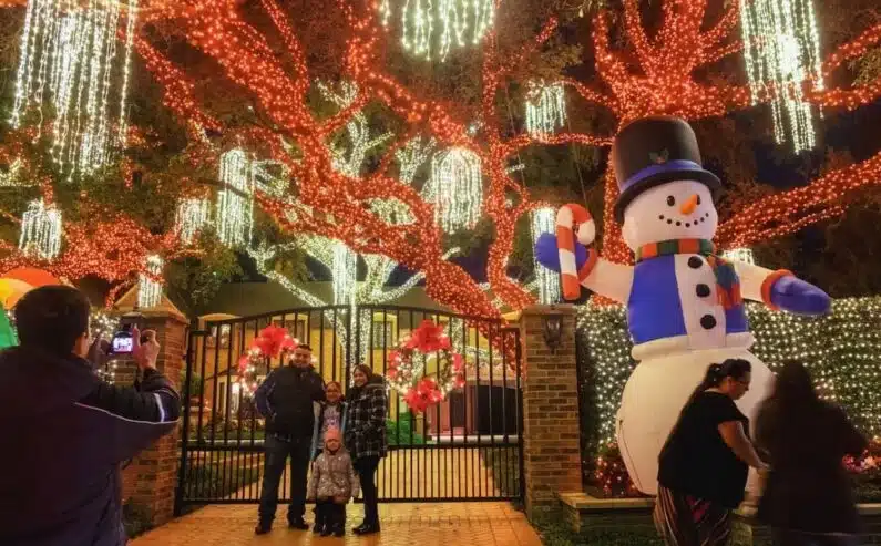 Image shows an immersive holiday displays in River Oaks Houston including oak trees in holiday lights and an inflatable snowman.