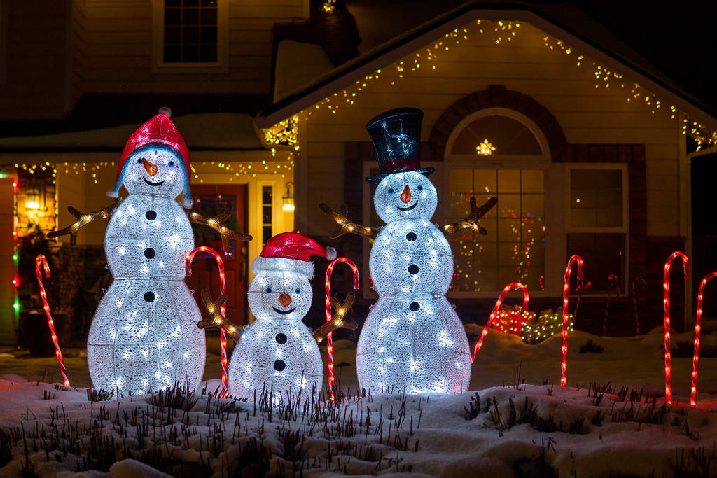 Image shows a snowman family installation outside of a house.