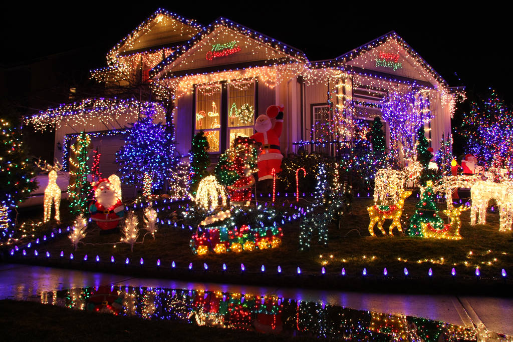 Image shows a home covered in holiday lights.