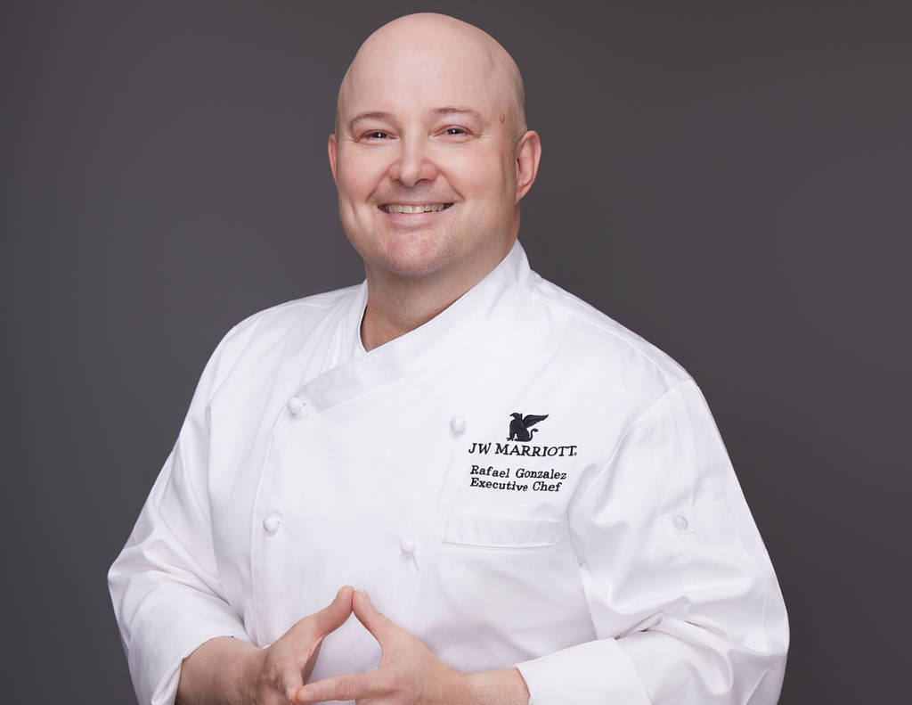 Image shows portrait of Executive Chef Rafael Gonzalez in chef ware.