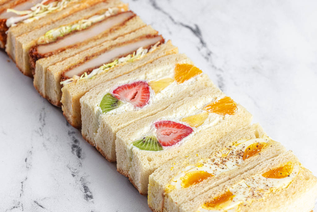 Image shows an array of Japanese sandwiches from Sandoitchi stacked on top of each other in a diagonal angle.