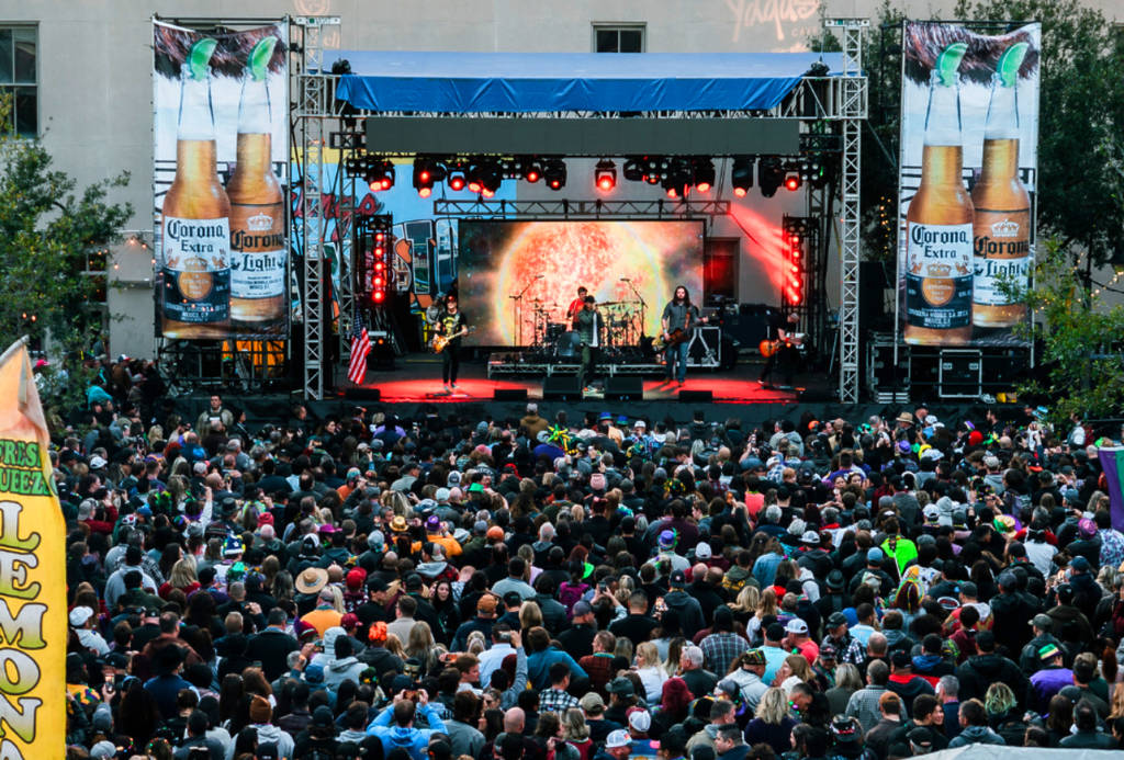 Image shows The Strand stage in Galveston for Mardi Gras! Galveston with a huge crowd in front.