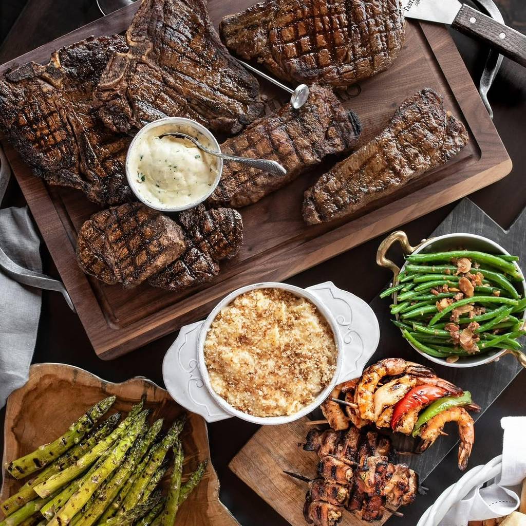 Image shows various dishes plated at Taste of Texas including steak, potatoes, and greens.