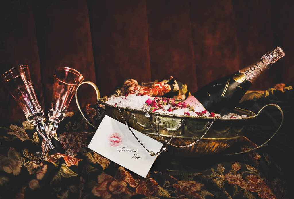 Image shows a display of cocktails and thematic elements for the L'Amour Noir pop-up in Houston.