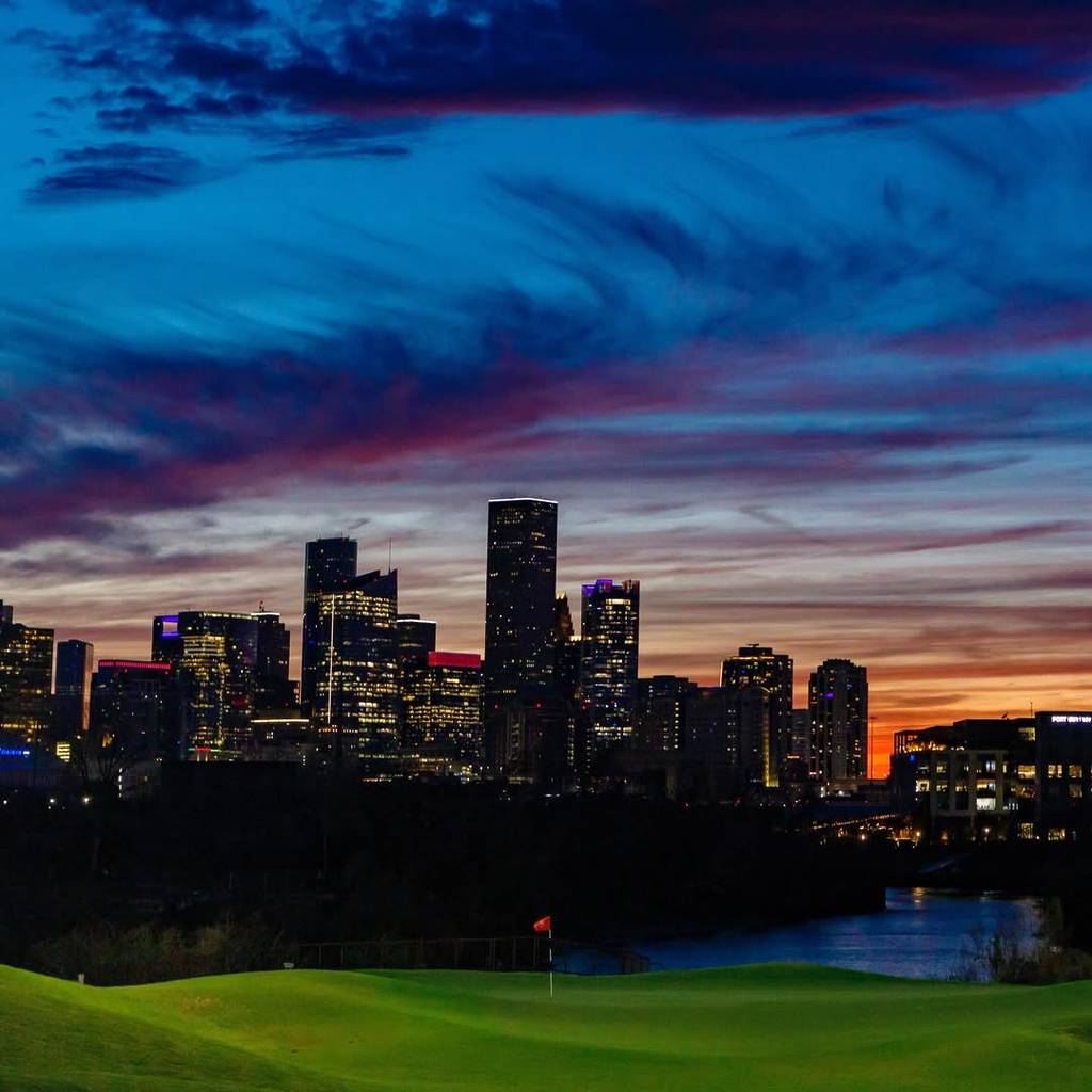Image shows a hole at East River 9 with the Houston skyline in the background.