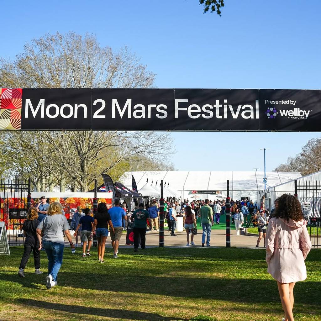 Image shows people entering the Moon 2 Mars Festival in Houston under the banner.