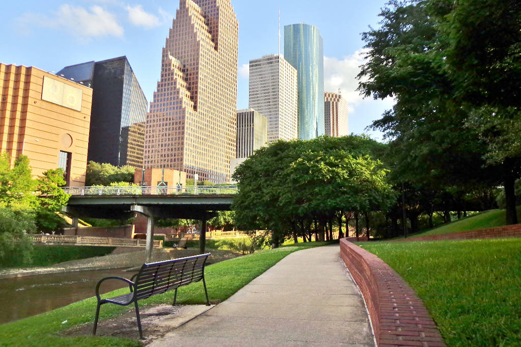Image shows a bench and the skyline in the background in Houston.