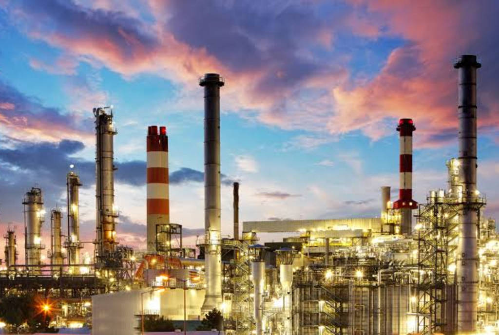 Image shows an oil refinery at sunset.
