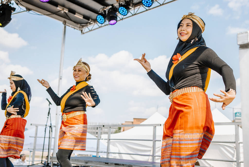 La imagen muestra a tres bailarines actuando en el escenario del Panda Fest.