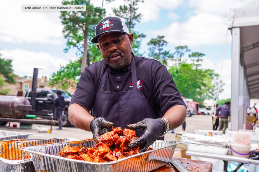 La imagen muestra a un chef preparando una bandeja de barbacoa en el Festival de Barbacoa de Houston. 