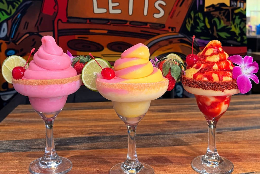 Image shows three soft-serve margaritas with the Doña Leti's sign in the background.