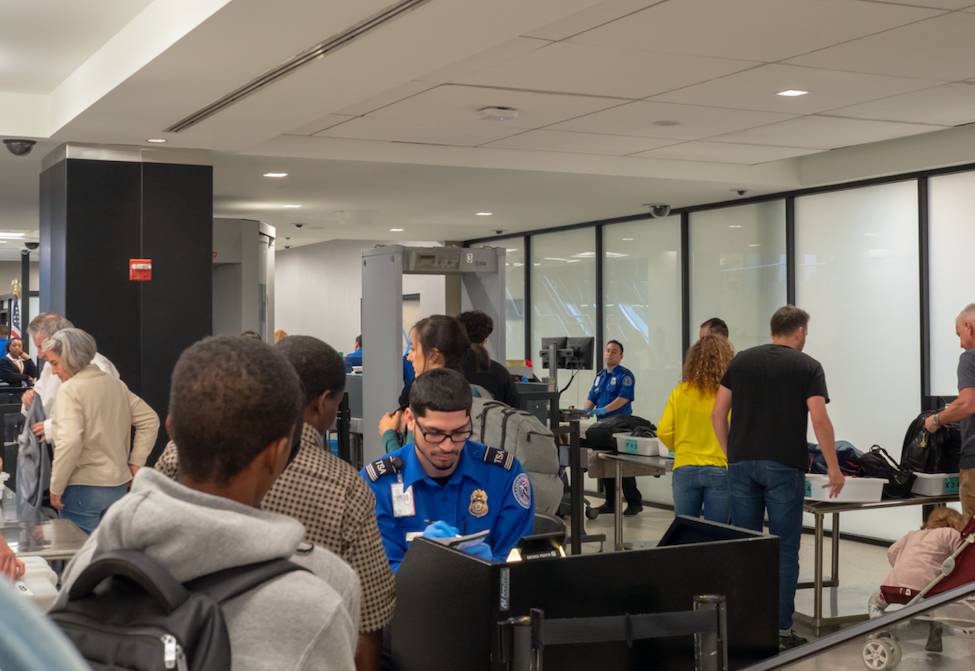La imagen muestra un control de seguridad en un aeropuerto.