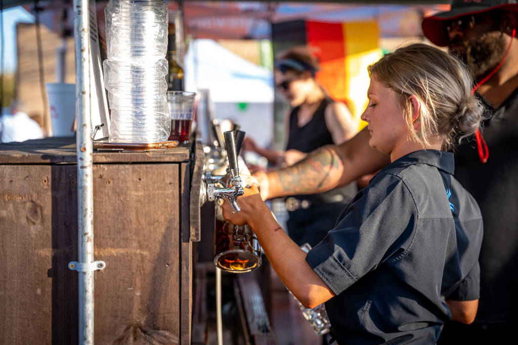 La imagen muestra a una mujer llenando un gran vaso de cerveza.