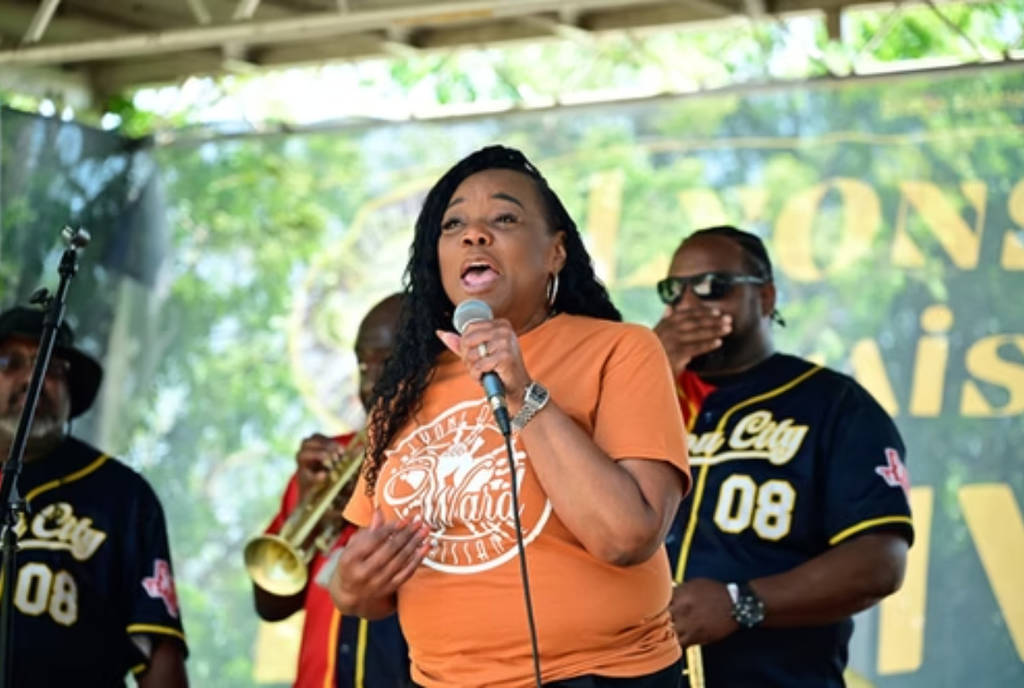 La imagen muestra a una mujer actuando en el escenario del Festival Renacentista de Lyons Avenue. 